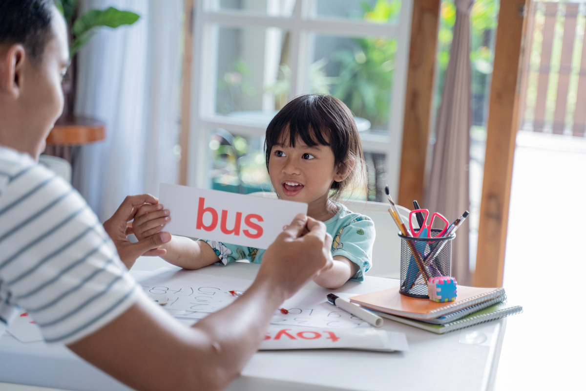 Dad Teaching Her Daughter to Read with Flashcard